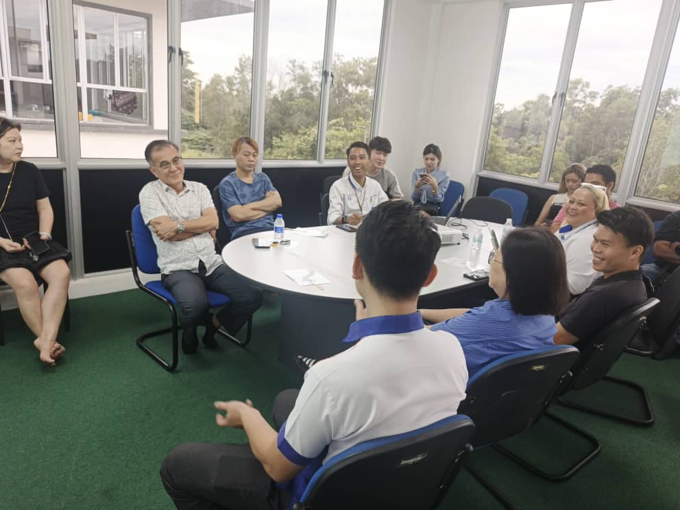 Factory owners seated around an oval table during the annual general meeting