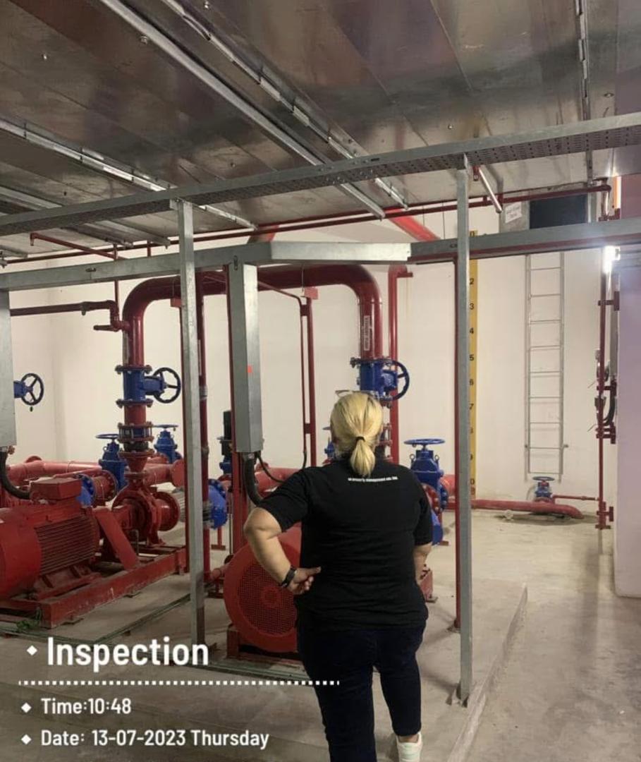 Nelfar Zulkifli walking the fire-fighting pump room, between the red pump sets and their pipework