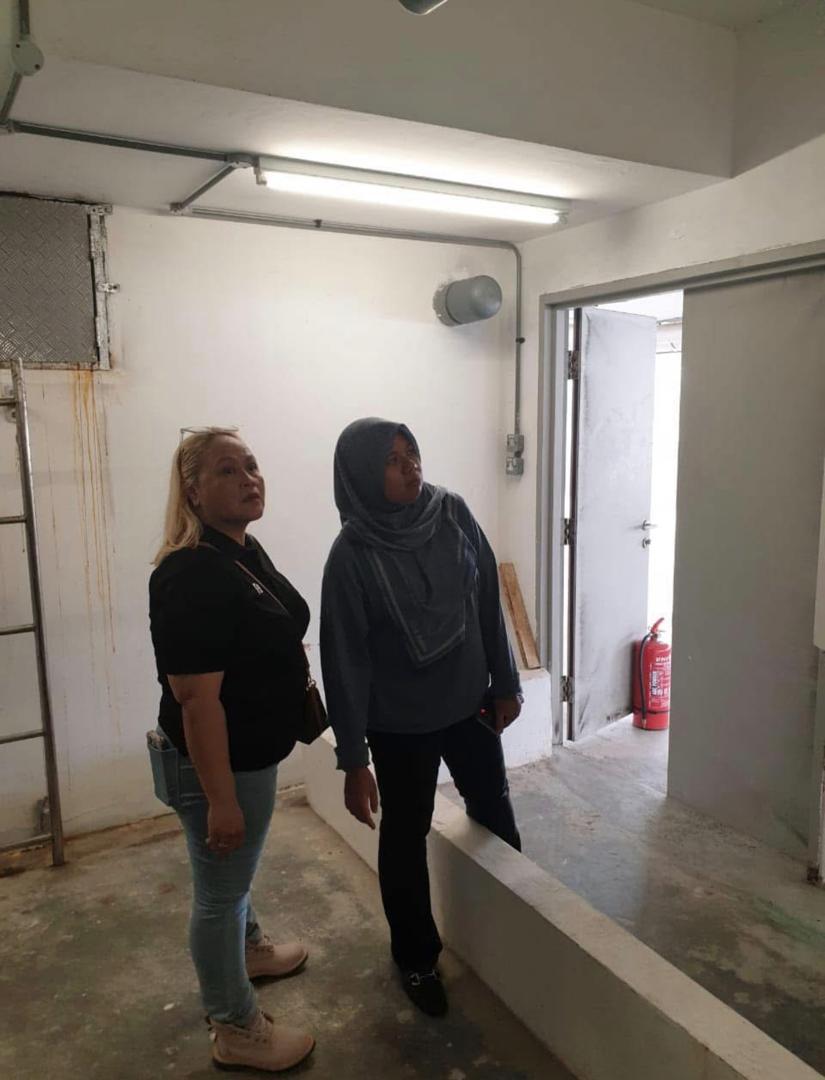 Nelfar Zulkifli and a colleague inspecting the ceiling and services of a bare plant room during a developer handover