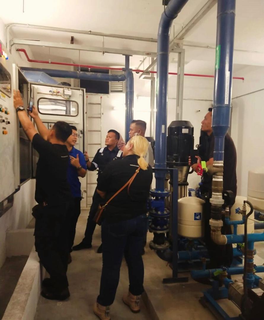 Nelfar Zulkifli and the site team at a control panel during the main contractor’s handover of a pump room