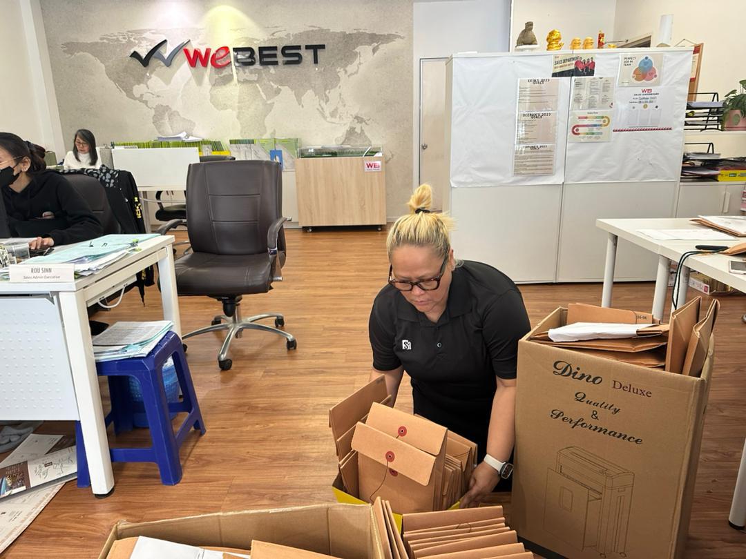 Nelfar Zulkifli sorting unit files into document boxes in an office