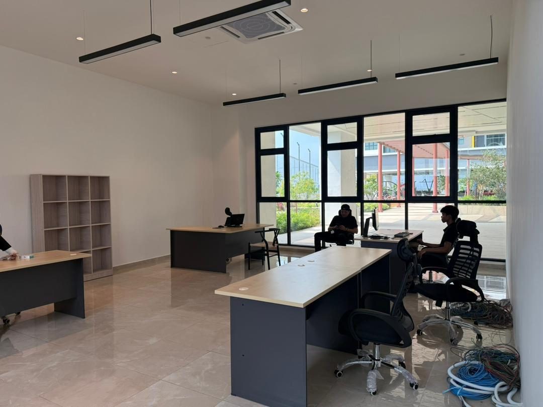 A management office mid fit-out with desks in place and cabling coiled on the floor