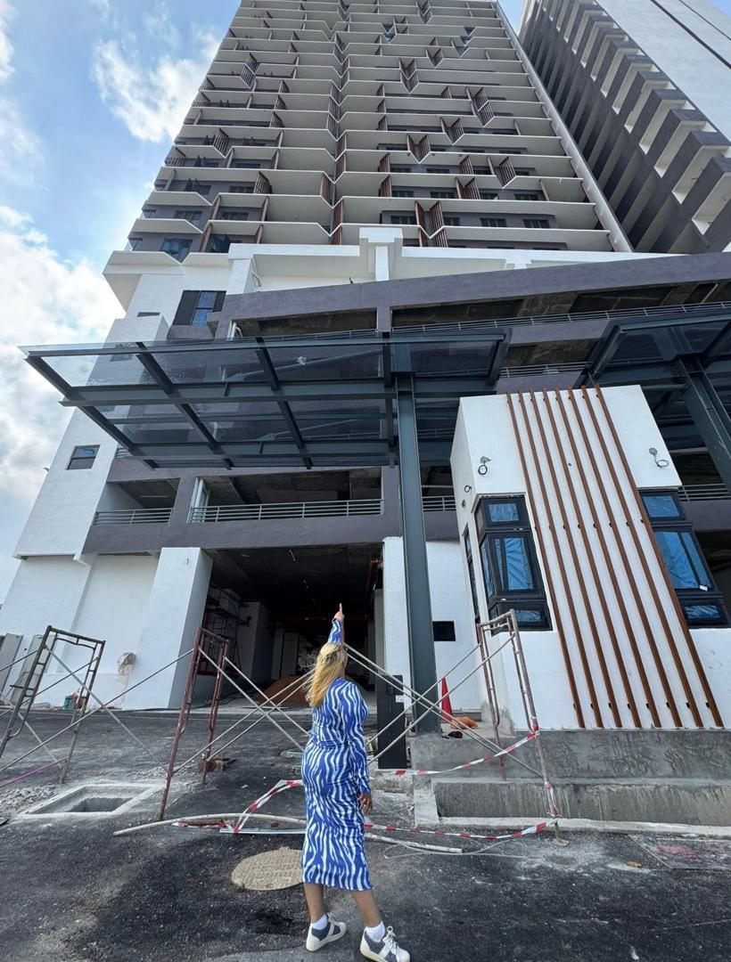 Nelfar Zulkifli looking up at a newly built residential tower from the drop-off, before handover