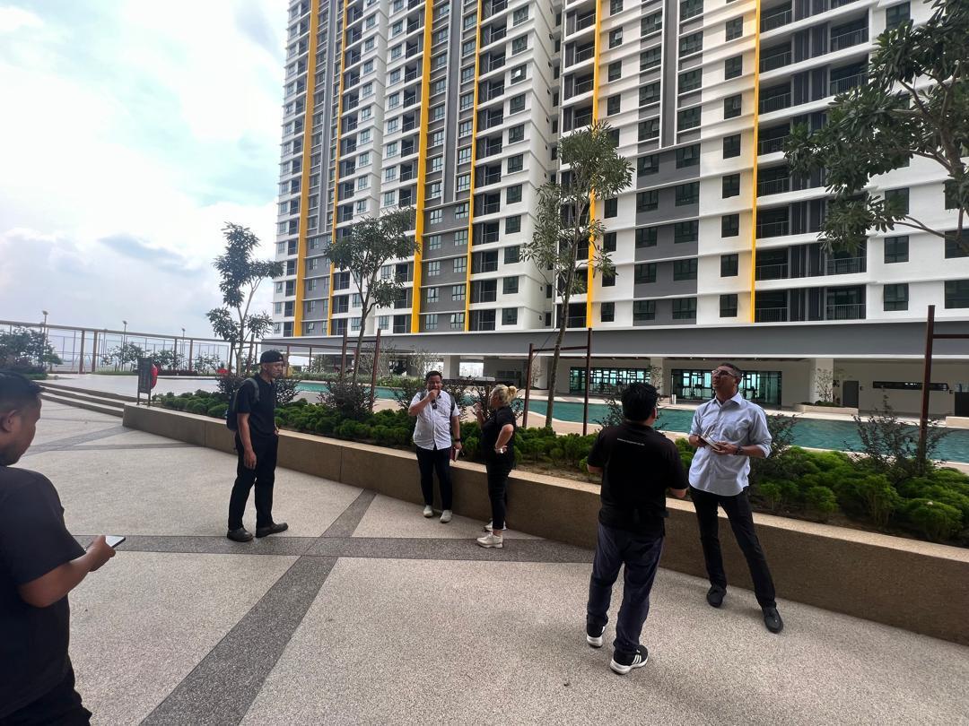 A group of vendors and management staff walking the pool deck of a new development