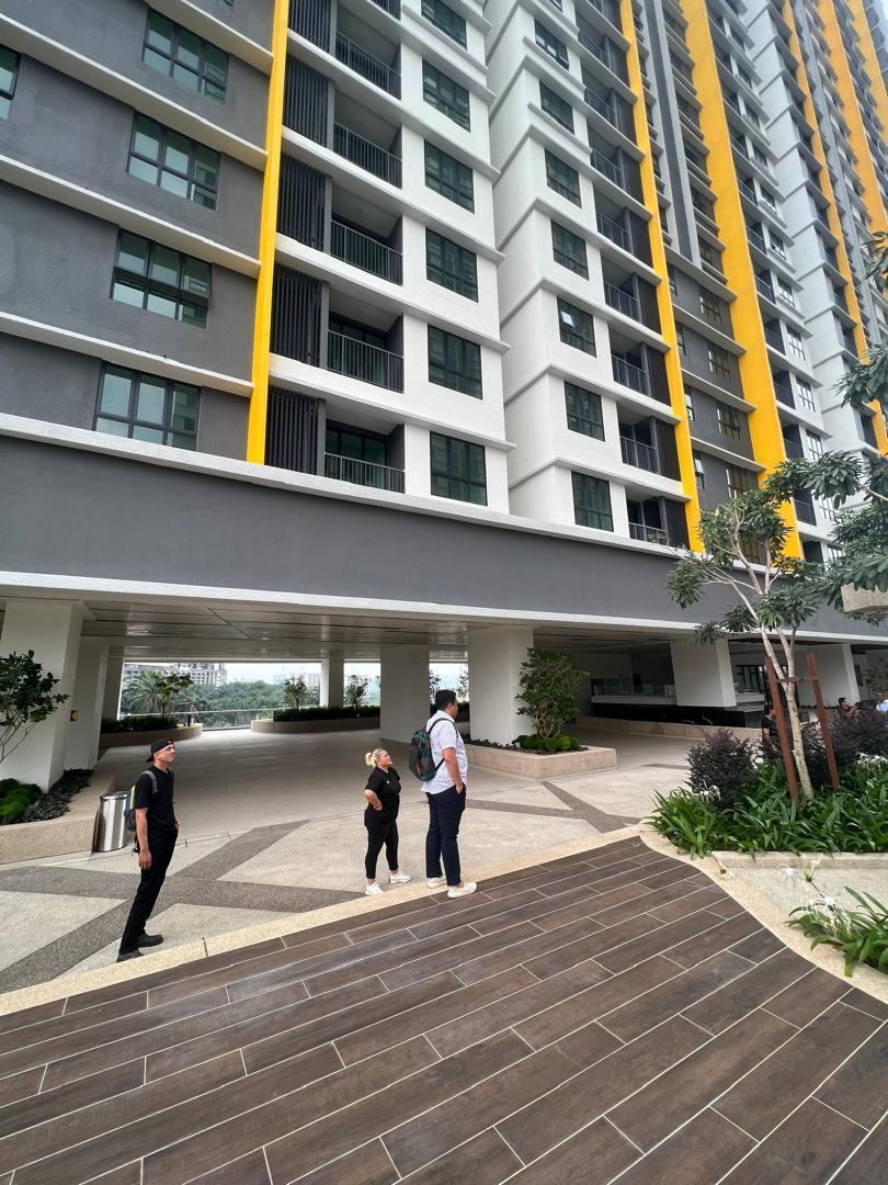 Vendors looking up at the facade of a completed high-rise from the drop-off