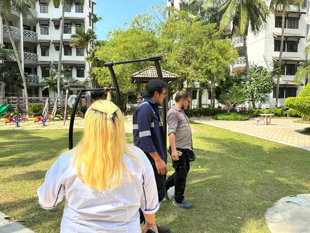 Nelfar Zulkifli walking a landscaped courtyard with the site team