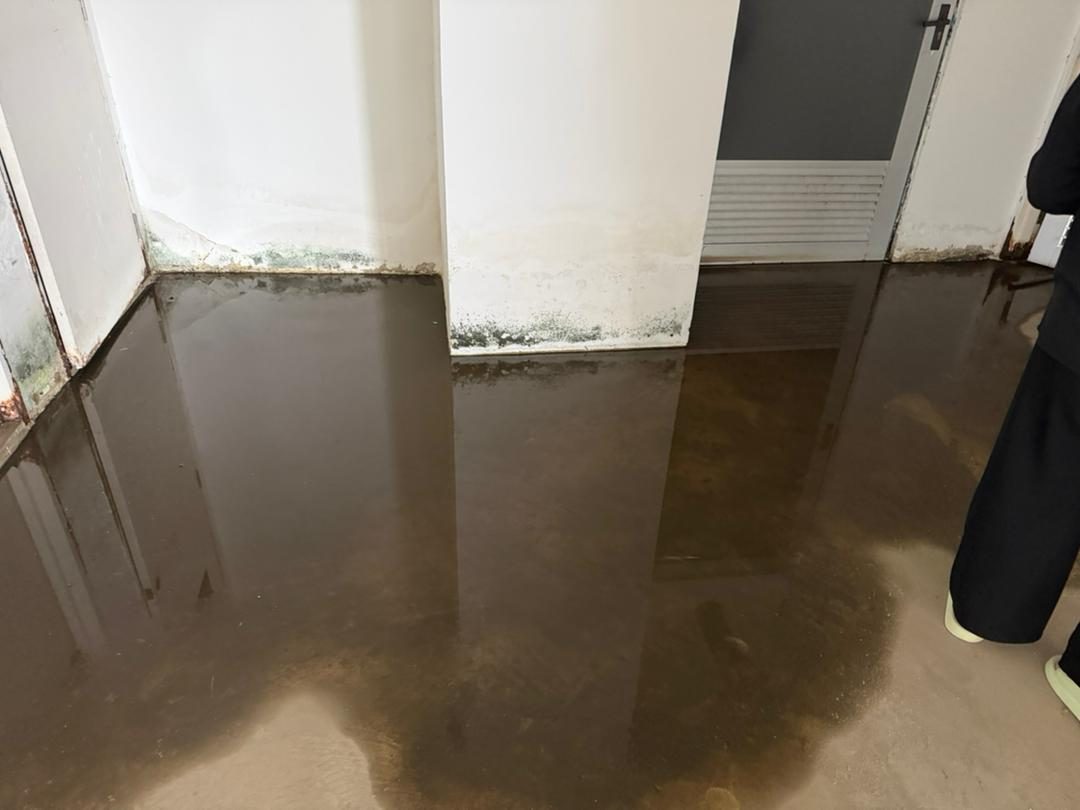 Standing water and staining across a bare concrete floor slab